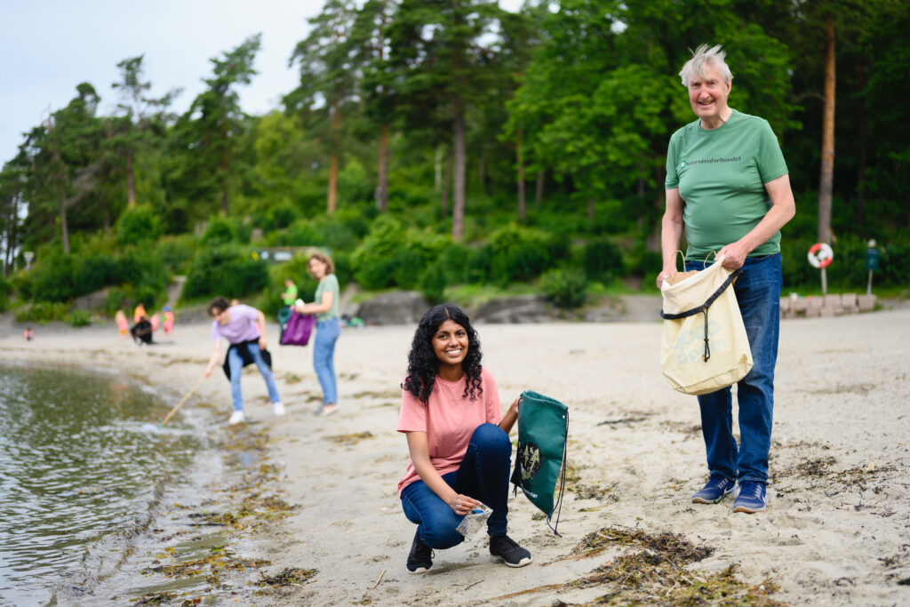 Mennesker som rydder stranden med Naturvernforbundet