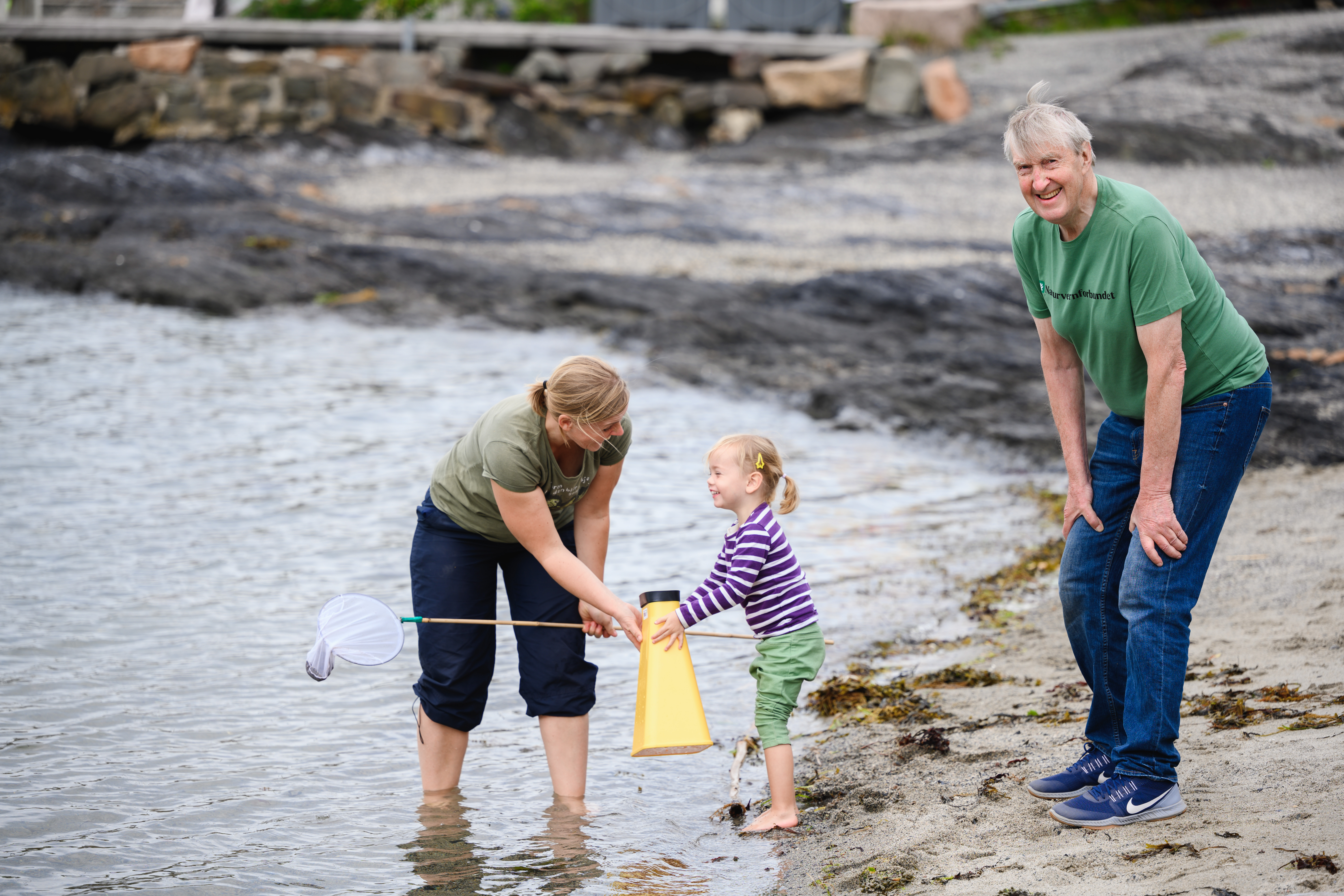 Familie som rydder stranden med Naturvernforbundet
