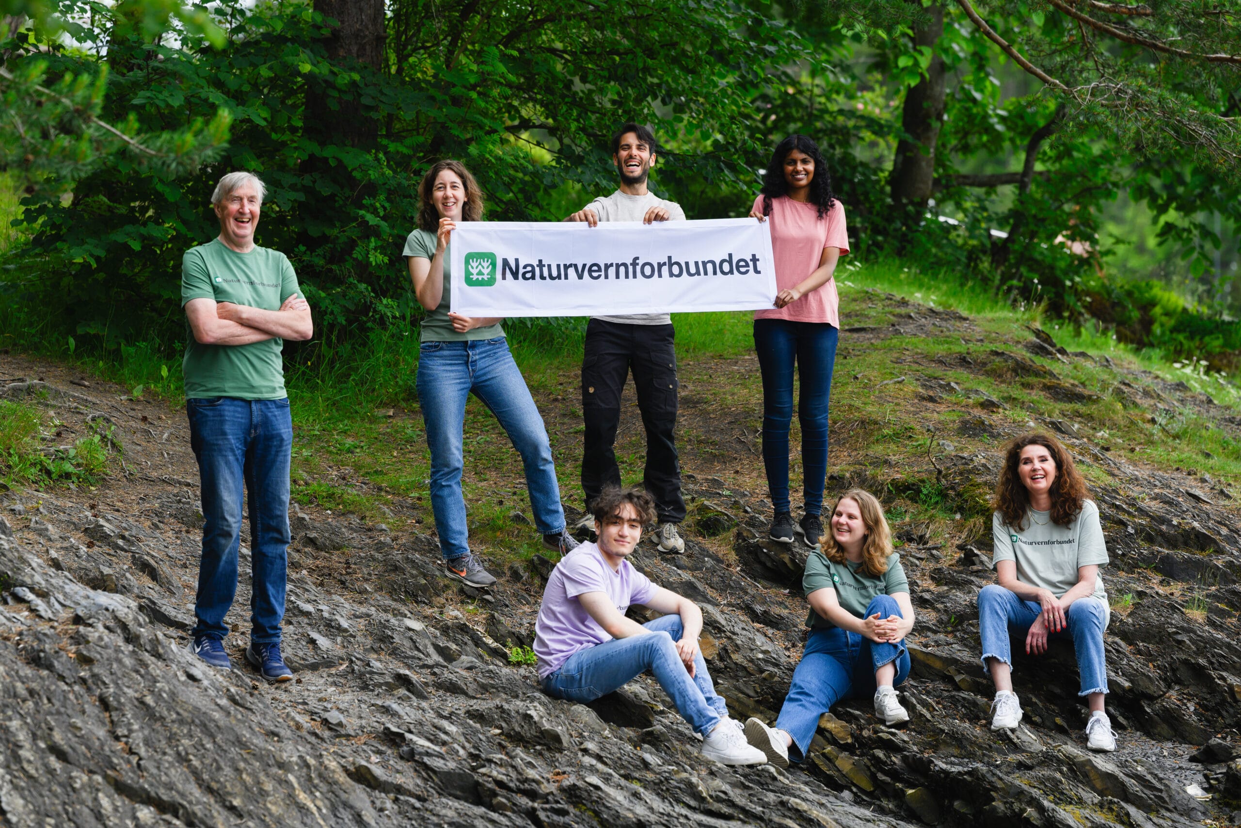 Gruppe mennesker holder opp et skilt av Naturvernforbundet