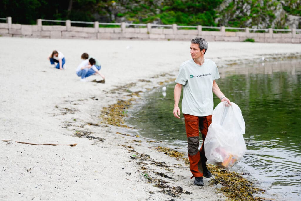 Truls Gulowsen som rydder stranden med Naturvernforbundet