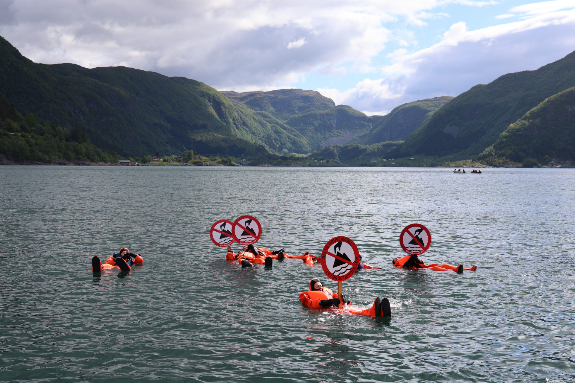 Aksjonister i Førdefjorden med håndplakater.