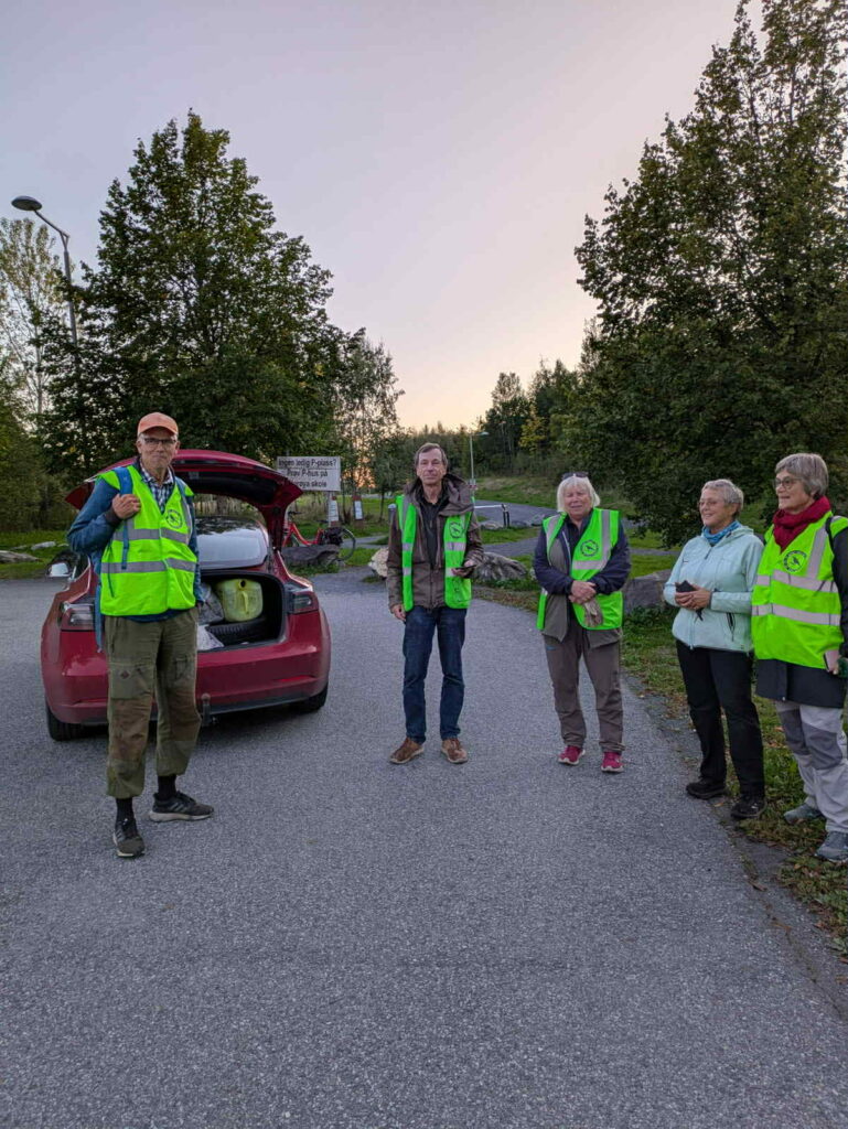 Dugnadsgjeng foran bil fylt med søppel
