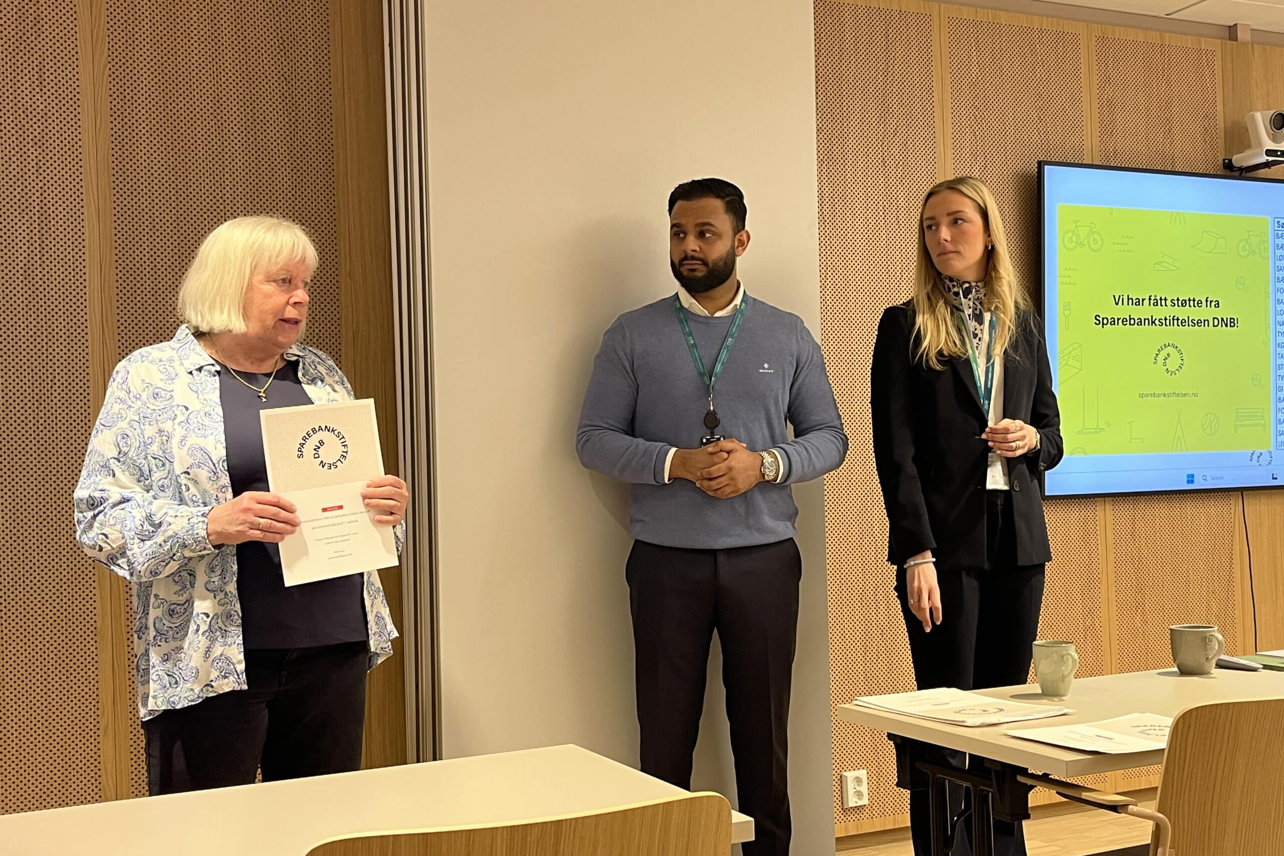 tre mennesker foran et møte