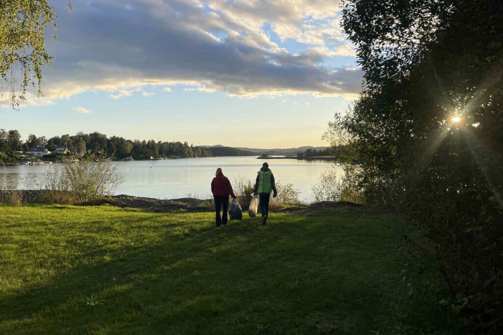 gress, sjø, trær, to mennesker, solnedgang