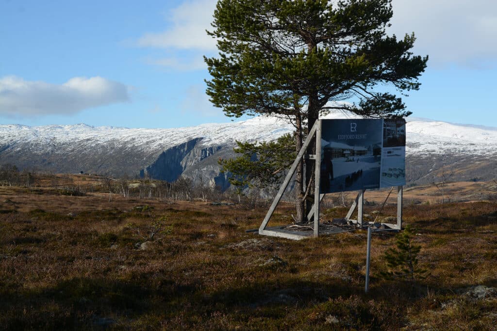 Reklameskilt for Eidfjord Resort foran storslått natur