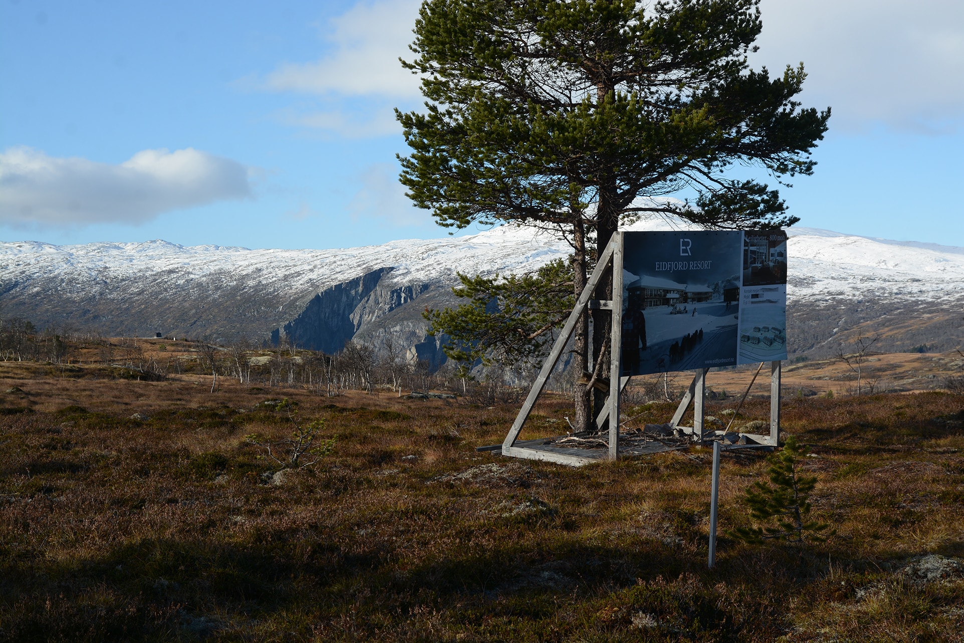 Reklameskilt for Eidfjord Resort foran storslått natur