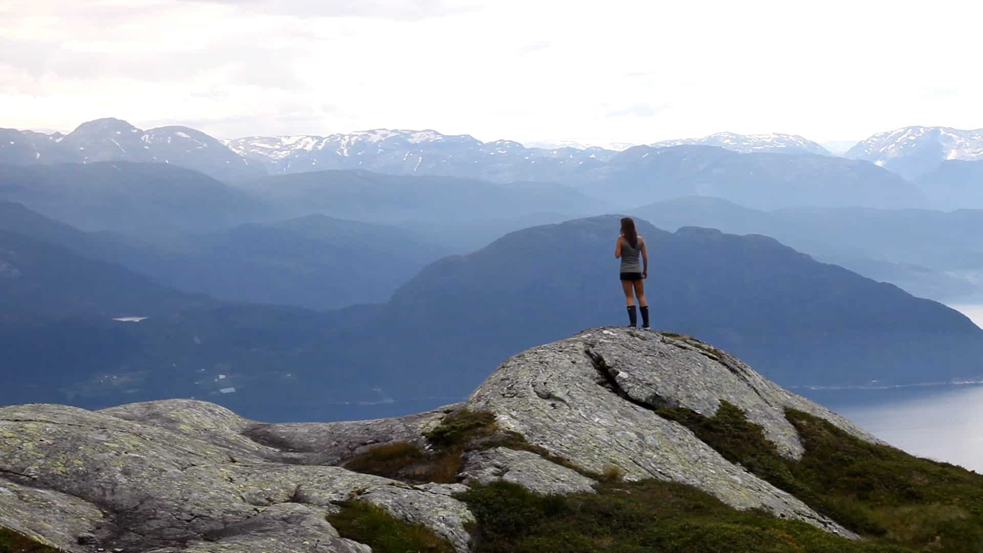 kvinne på fjell over fjord